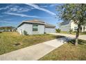 One-story home with gray exterior, attached garage, and manicured lawn at 168 Taft Dr, Davenport, FL 33837