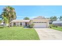 Brick ranch house with a large driveway and palm tree at 2204 Clementine Trl, Clermont, FL 34714