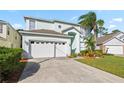 Two-story house with light teal exterior, white garage door, and landscaped lawn at 1055 Lake Berkley Dr, Kissimmee, FL 34746