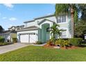 Two-story house with light teal exterior, white garage door, and landscaped lawn at 1055 Lake Berkley Dr, Kissimmee, FL 34746