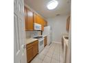 Kitchen with light oak cabinets, white appliances, and tile flooring at 2484 San Tecla # 303, Orlando, FL 32835
