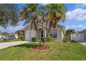 Tan house with a white garage door and palm trees at 1957 Teaberry Ct, Orlando, FL 32824