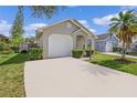 Tan house with a white garage door and palm trees at 1957 Teaberry Ct, Orlando, FL 32824