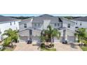 Modern three-unit townhome building with attached garages at 543 Ocean Course Ave, Davenport, FL 33896
