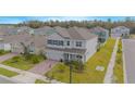 Two-story house with gray exterior, a brick driveway, and a landscaped lawn at 5045 Rain Shadow Dr, St Cloud, FL 34772