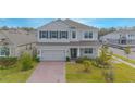 Two story house with paver driveway and front yard at 5045 Rain Shadow Dr, St Cloud, FL 34772