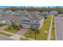 Two-story house with gray exterior, a brick driveway, and a landscaped lawn at 5045 Rain Shadow Dr, St Cloud, FL 34772