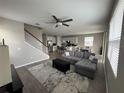 Spacious living room with gray sectional sofa, open floor plan, and kitchen view at 853 Blue Creek Dr, Haines City, FL 33844