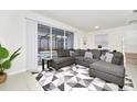 Open living room showcasing a sectional sofa, large windows, and access to a pool at 287 Jetty Way, Davenport, FL 33897