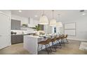 Modern kitchen with gray cabinets, a large island, and stylish pendant lights at 12614 Clear Sapphire Dr # 137, Winter Garden, FL 34787
