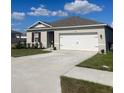 One-story house with a two-car garage, landscaped lawn, and neutral exterior at 564 Boardwalk Ave, Haines City, FL 33844