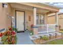 Inviting front porch with white railings, potted plants, and a welcoming sign at 2879 Paynes Prairie Cir, Kissimmee, FL 34743