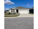 Curb appeal of a single-story home featuring a two-car garage and well-maintained lawn at 564 Boardwalk Ave, Haines City, FL 33844