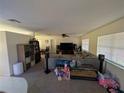 Spacious living room featuring a large sectional sofa and a flat-screen TV at 1301 Redwood Ct, Tavares, FL 32778