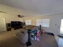 Bright living room with sectional sofa, large TV, and lots of natural light at 1301 Redwood Ct, Tavares, FL 32778