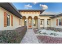 Elegant entryway with arched entry, stone accents, and meticulously landscaped grounds at 38748 Lakeview Walk, Lady Lake, FL 32159