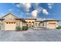 Front view of a two-story house with a three-car garage and a stone facade at 38748 Lakeview Walk, Lady Lake, FL 32159