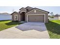 New house with driveway, two-car garage, and grassy front yard at 279 Fig Ct, Poinciana, FL 34759