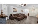 Spacious living room with L-shaped sectional sofa and wood-look tile floors at 2430 Norwood Pl, Tavares, FL 32778