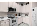 White kitchen with stainless steel appliances and ample counter space at 101 New Providence # 9101, Davenport, FL 33897
