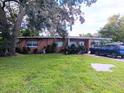 Front view of ranch house with landscaping and driveway at 222 Ronnie Cir, Orlando, FL 32811