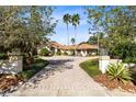 Grand entrance to a beautiful home with a long paved driveway and lush landscaping at 4024 W Danby Ct, Winter Springs, FL 32708