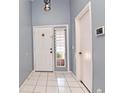 Bright entryway with tile flooring, white door, and window with blinds at 1453 Brookebridge Dr, Orlando, FL 32825