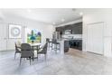 Modern kitchen with dark cabinetry, island, and dining area at 1910 Lakeview Ln, Poinciana, FL 34759