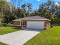 Newly built single-story home with attached garage and manicured lawn at 2886 Se 140Th Pl, Summerfield, FL 34491