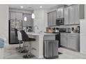 Modern kitchen with gray cabinets, quartz countertops, and island at 1092 Downswing Pl, Davenport, FL 33896