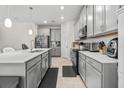 Modern kitchen with gray cabinets, quartz countertops, and island at 1092 Downswing Pl, Davenport, FL 33896