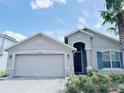 Two-story home with gray exterior, paver driveway, and lush landscaping at 3995 Scarlet Branch Rd, Orlando, FL 32824