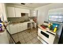 Kitchen needing renovation, features white cabinets and appliances at 453 E Jessup Ave, Longwood, FL 32750