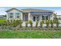 New home with gray siding, stone accents, and landscaped yard at 863 Pebble Crest Ln, Eagle Lake, FL 33839