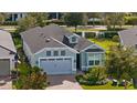 Single-story house with gray garage and light-blue exterior. Landscaped yard and brick driveway at 2160 Antilles Club Dr, Kissimmee, FL 34747