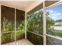 Cozy screened porch with tiled floor and lush greenery views at 2373 Greenwood St, Deltona, FL 32738