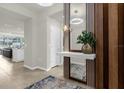 Elegant entryway with a modern wood accent wall and large mirror at 4306 Lana Ave, Davenport, FL 33897