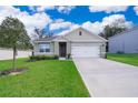 Front exterior of a single-story home with a two-car garage and landscaped yard at 3759 Rory Oak Cir, Apopka, FL 32703