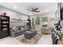 Spacious living room with fireplace, gray sofa, and ceiling fan at 5128 Caspian St, Saint Cloud, FL 34771