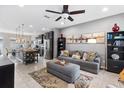 Open living room and kitchen with island, gray sofa, and ceiling fan at 5128 Caspian St, St Cloud, FL 34771