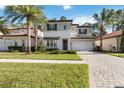 Two-story house with gray and white exterior, a dark door, and a brick driveway at 10159 Royal Island Ct, Orlando, FL 32836