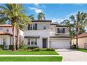 Two-story house with gray and white exterior, a dark door, and a brick driveway at 10159 Royal Island Ct, Orlando, FL 32836