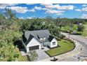 Aerial view of a modern farmhouse on a tree-lined street at 155 Pearl St, Auburndale, FL 33823