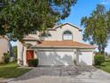 Two-story house with two-car garage and lush landscaping at 162 Harwood Cir, Kissimmee, FL 34744