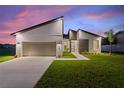 Modern home exterior at dusk, showcasing contemporary design at 1877 Snapper Dr, Kissimmee, FL 34759