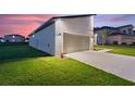 Attached two-car garage with modern design, additional exterior lighting at 1877 Snapper Dr, Kissimmee, FL 34759
