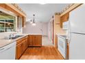 Galley kitchen with wood cabinets and white appliances at 2900 Lake Arnold Pl, Orlando, FL 32806