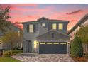 Two-story house with gray siding, stone accents, and a two-car garage at 365 Southfield St, Kissimmee, FL 34747