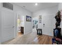 Bright foyer with wood-look floors, built-in shelving, and access to bathroom at 928 Orchid Grove Blvd, Davenport, FL 33837