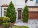 Elegant front door flanked by lush greenery at 10564 Royal Cypress Way, Orlando, FL 32836